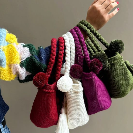 Colorful, crochet bags with pom-poms and tassels, made in Colombia by Wayuu artisans