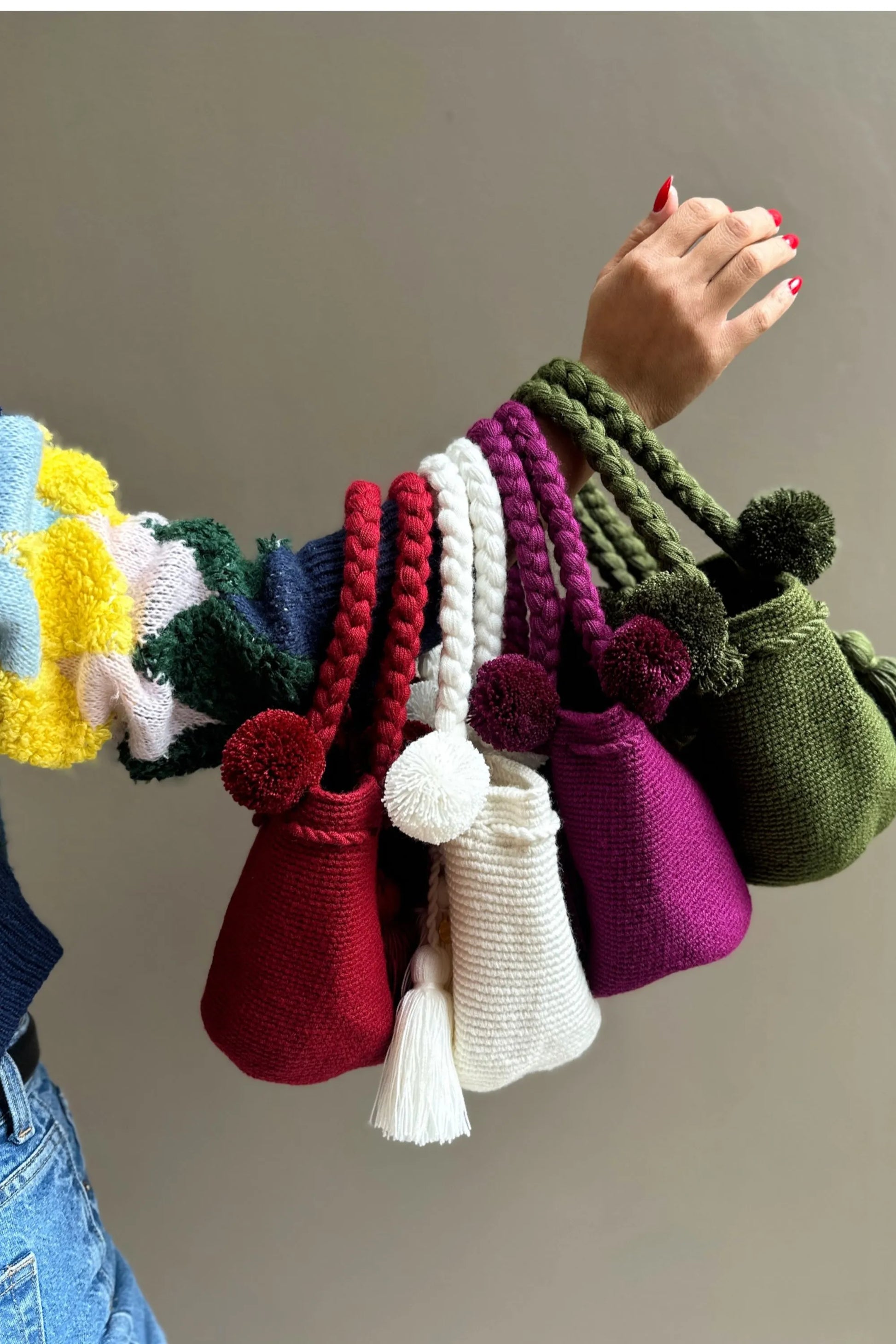 Colorful, crochet bags with pom-poms and tassels, made in Colombia by Wayuu artisans